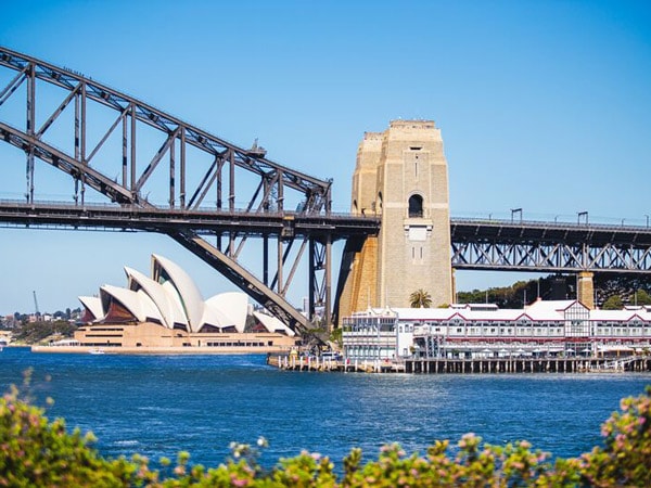 A photo of a bridge over water with the opera house.
