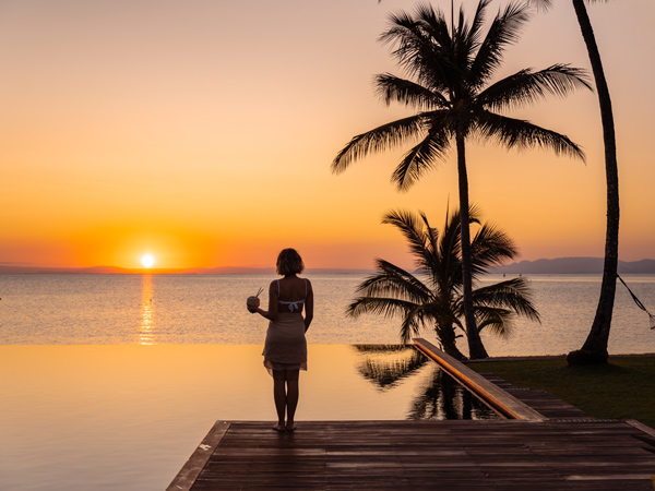 a woman admiring the sunset by the pool at Orpheus Island Lodge, Townsville