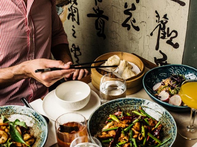A man sitting at a table with Asian food.