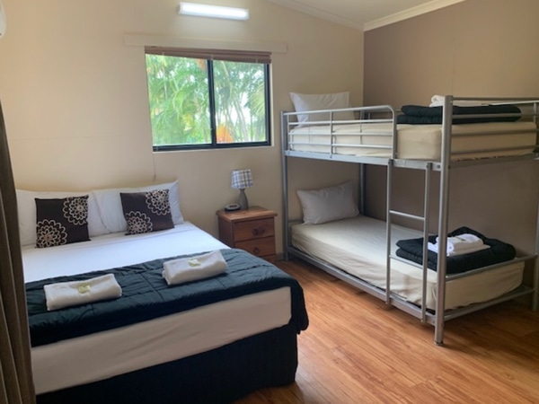 a double bed and two bunk beds inside the ensuite cabin at 