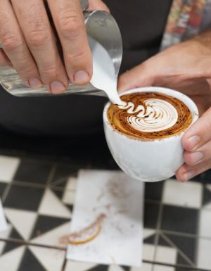 Pouring milk over coffee at Ray’s Patisserie and Cafe, Darwin