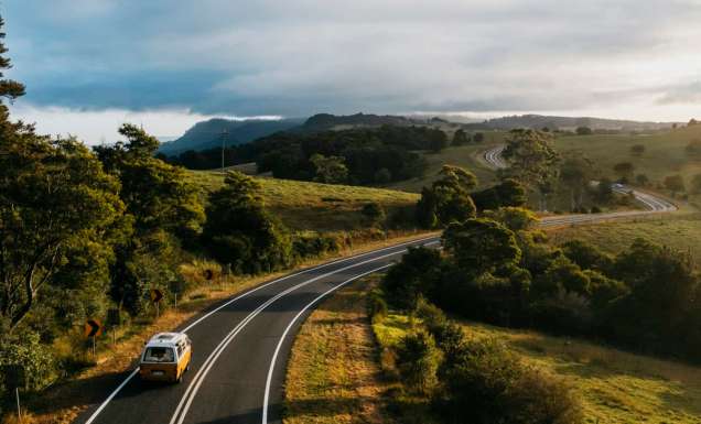 Yellow campervan driving down country roads in Bellingen