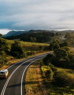 Yellow campervan driving down country roads in Bellingen
