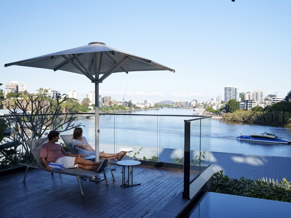 a couple relaxing on a sunlounger at Howard Smith Wharves