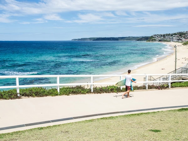 a person holding a surfboard at Merewether Beach, Newcastle