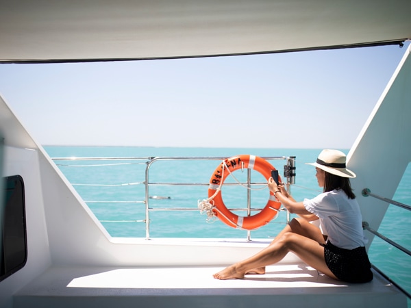 Woman taking selfie on ship deck. 