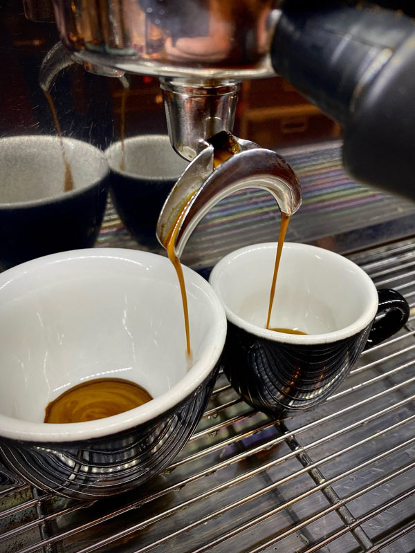 pouring coffee into two cups at Yellow Bernard, Hobart