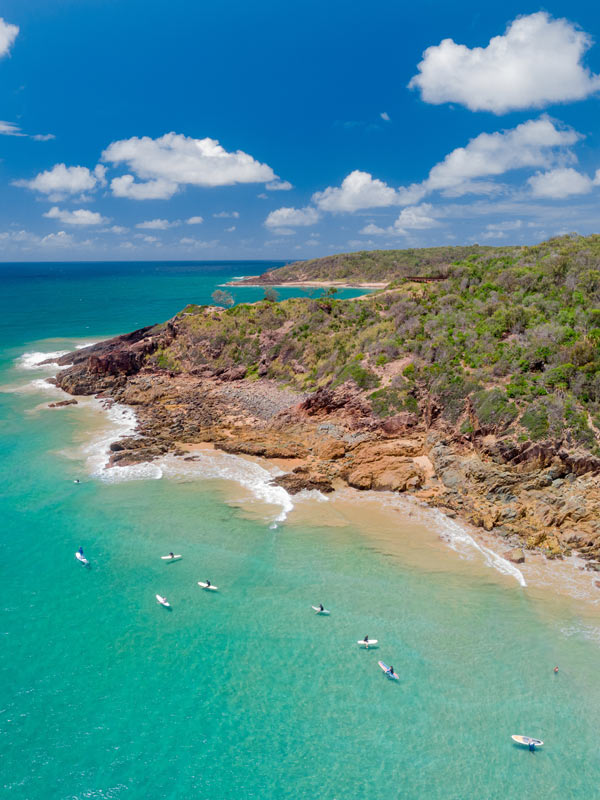 Surfers waiting for a surf break at Agnes Water Main Beach in Queensland.