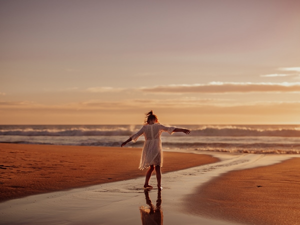 Child dancing on Maslin Beach at sunset