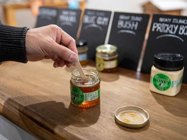 a person's hand stirring honey
