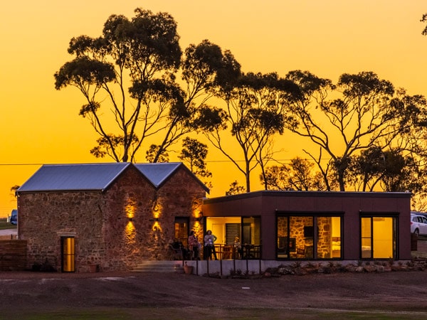 the exterior of Hutton Vale Farm behind a dramatic orange sunset sky background