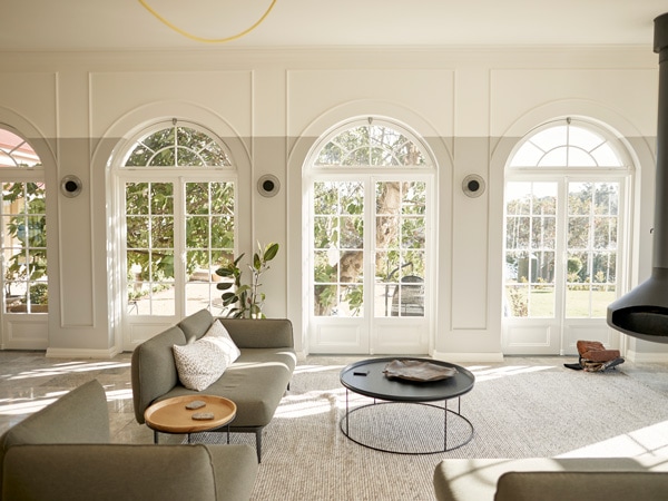 a french-inpired living room interior with wide windows letting natural light in