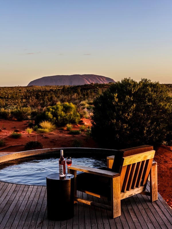 a bottle of wine on the table beside the lodge pool in Uluru