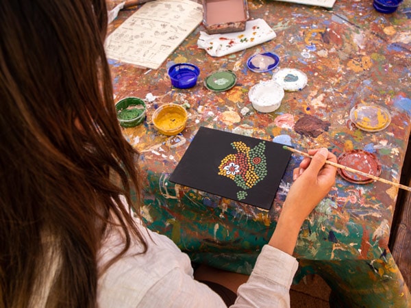 a local Anangu artist and her Maruku dot-painting artwork