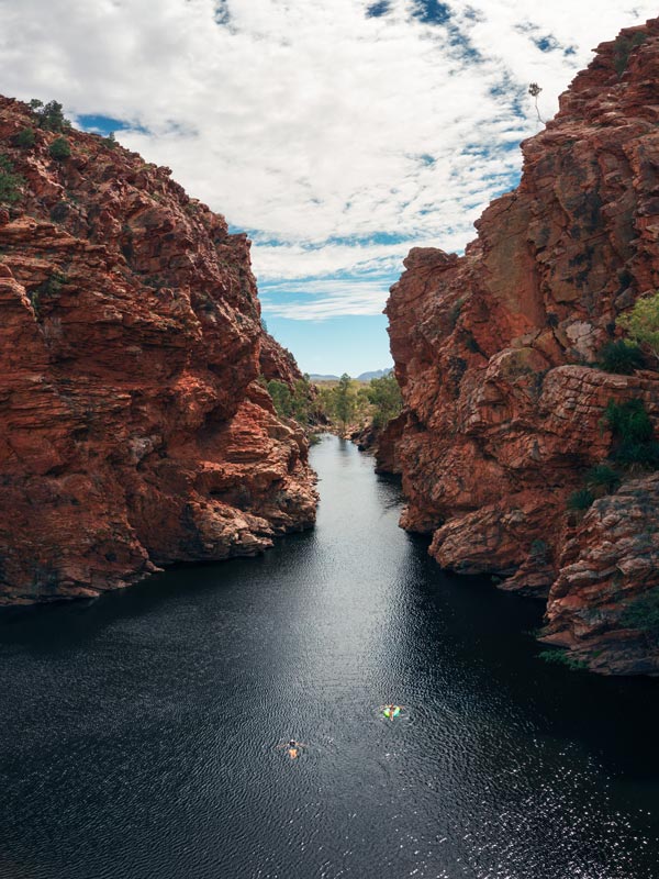 swimming in the calm waters of the Ellery Creek Big Hole between rugged cliffs in Uluru