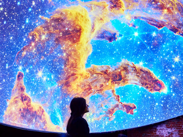 a woman admiring a planetarium installation at Discover Science & Technology Centre 