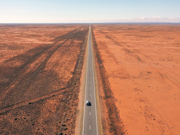 an aerial shot of a vehicle driving in the outback near Broken Hill