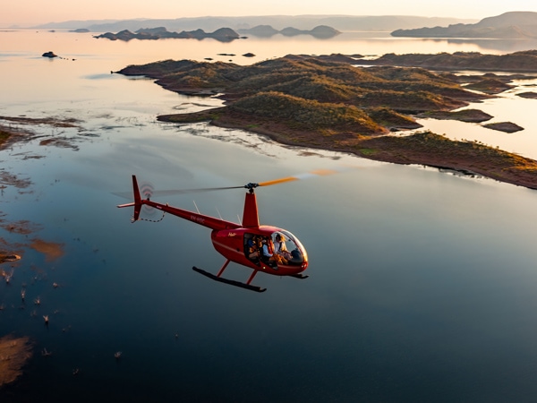 a helicopter soaring over Lake Argyle