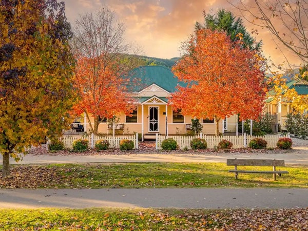 the exterior of Autumn Beauty Cottages with colourful autumn trees on the background