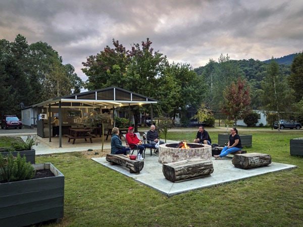 a group of friends gathering around a bonfire at Discovery Parks Bright
