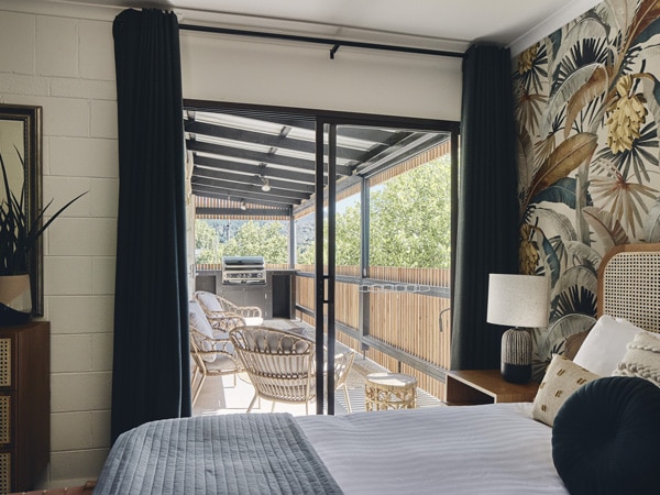 a bedroom with sliding glass doors leading to the open-air deck