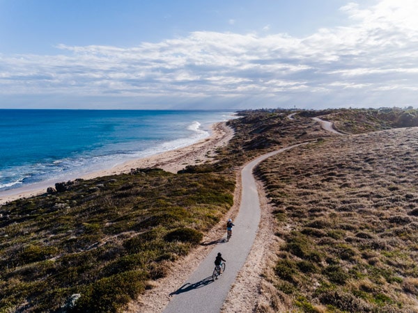 Two people cycle the coastal trail in Mandurah