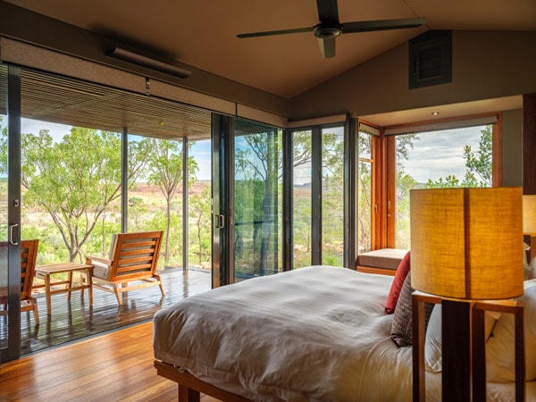 a bedroom with balcony facing a garden view at El Questro Homestead