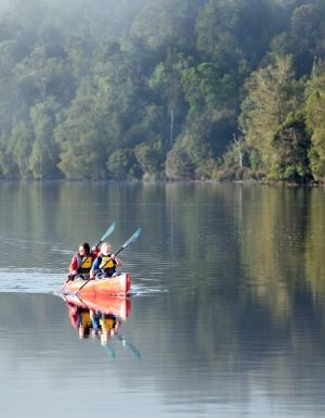 a mother and daughter kayaking through the waters of Pieman River