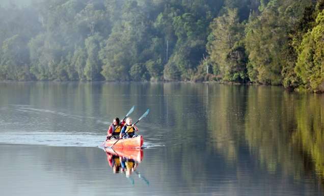 a mother and daughter kayaking through the waters of Pieman River