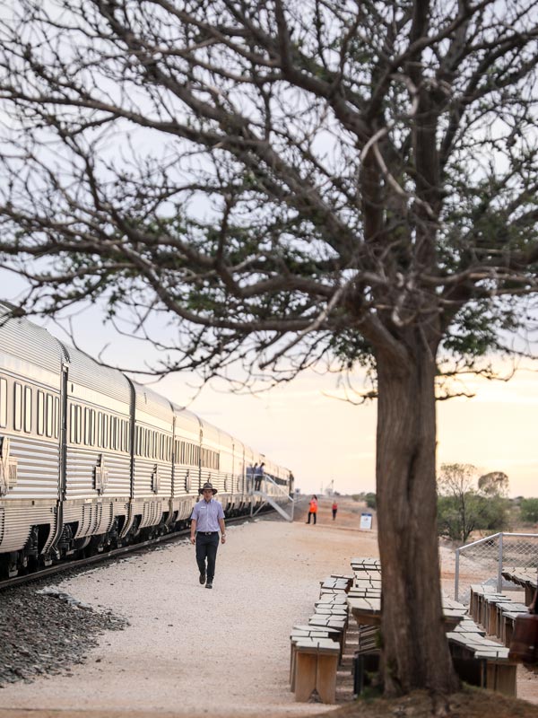 a man standing outside Indian Pacific train in Rawlinna outpost