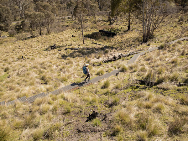 a woman walking along the Mount Tennent Trail, Canberra