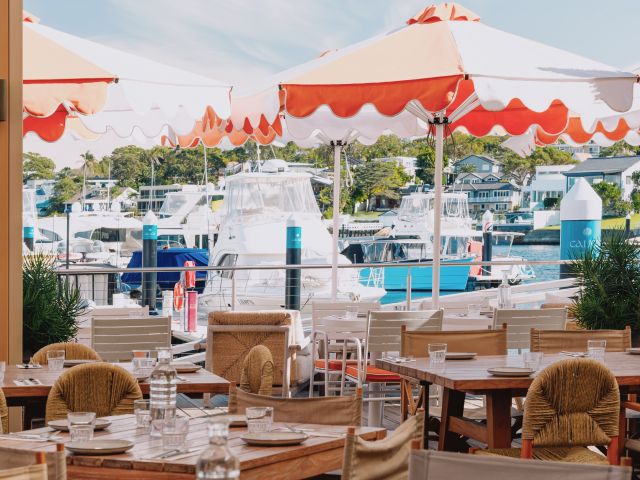 an outdoor dining setup with colourful umbrellas at Pippis Cronulla