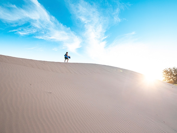 sandboarding down Perry Sandhills