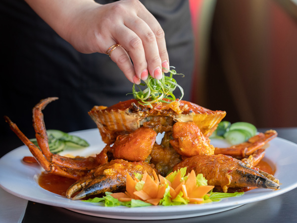 putting garnish on top of a mud crab dish at The Noodle House, Darwin
