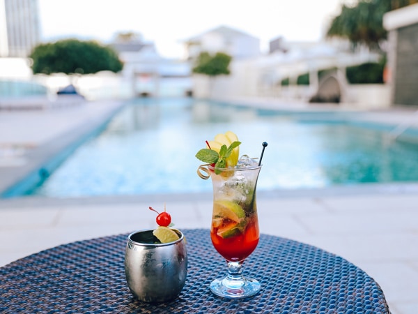a cocktail drink on the table beside the pool at Hilton Surfers Paradise Hotel & Residences