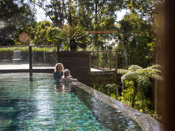 a couple relaxing in the pool at Gwinganna Lifestyle Retreat, Gold Coast suburbs