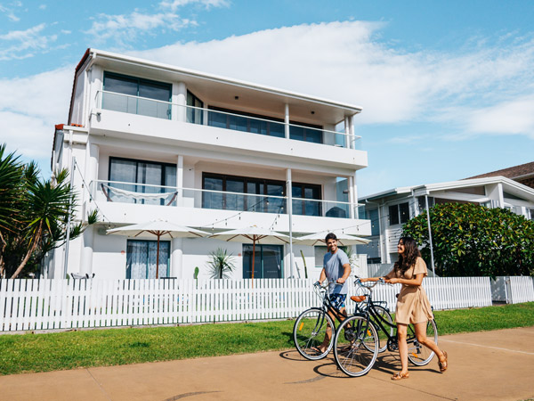 a couple with their bicycles outside Tessa’s on the Beach motel, Gold Coast