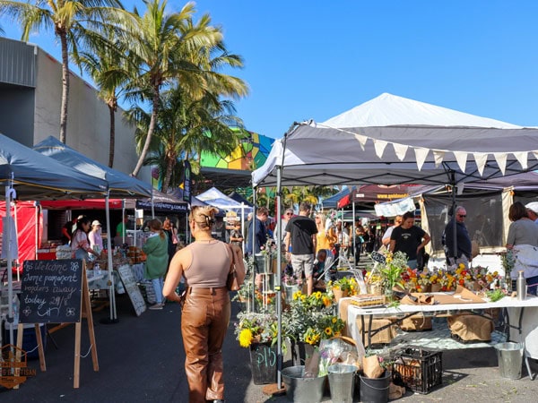 a woman browsing through the fresh produce stalls at HOTA