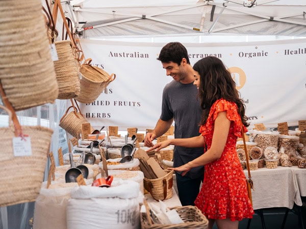 a couple browsing through a handicraft stall at Palm Beach Farmers Market