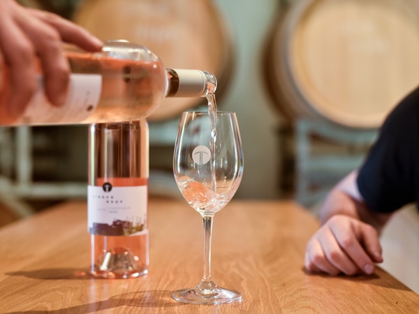 a hand pouring wine into a glass