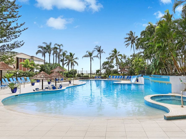 an outdoor pool surrounded by palm trees at Royal Palm Resort