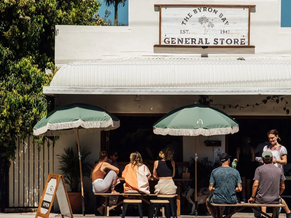 people sitting under umbrellas outside The Byron Bay General Store