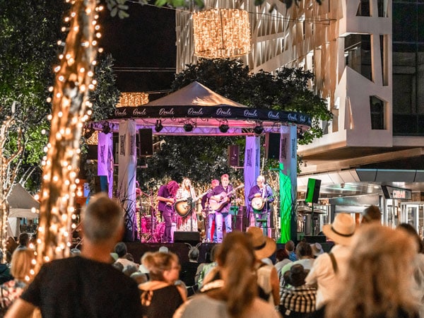 a band performing in front of a crowd at the Groundwater Country Music Festival