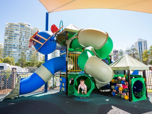 a child on a slide at the Main Beach Tourist Park playground