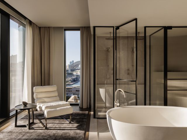 A hotel bathroom with a freestanding bath overlooking Sydney Harbour Bridge