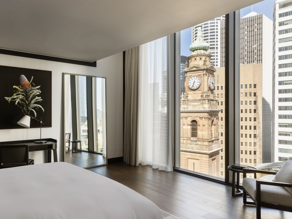 A modern hotel room looking out to a clock tower.