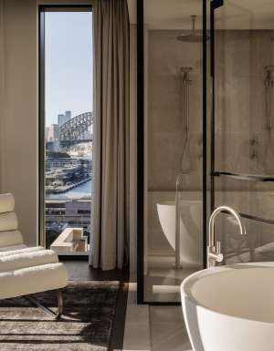 A hotel bathroom with a freestanding bath overlooking Sydney Harbour Bridge