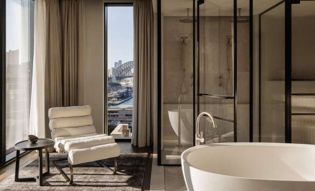 A hotel bathroom with a freestanding bath overlooking Sydney Harbour Bridge