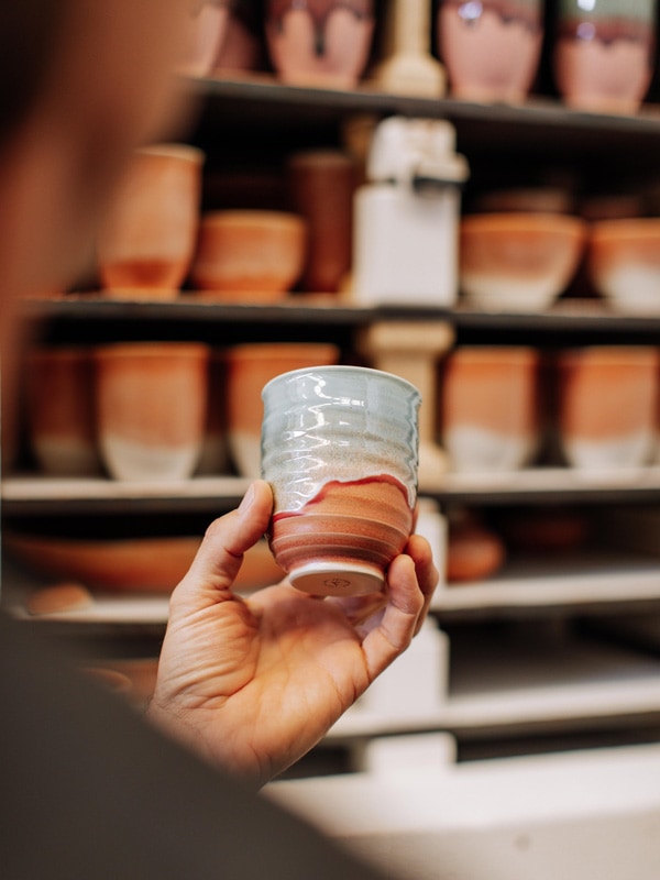 a hand holding a ceramic pot at Pottery For The Planet