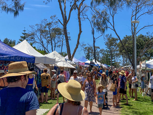 crowd of people perusing the stalls at Byron Bay Community Markets
